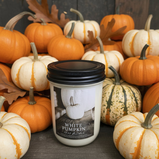 Candle labeled 'White Pumpkin' on a wooden surface