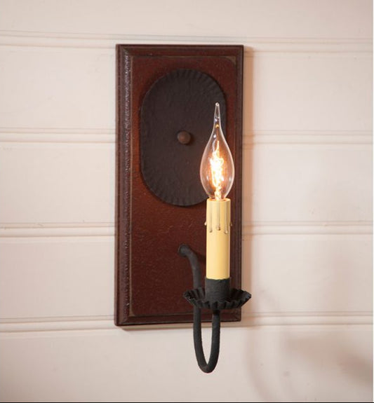Wall-mounted light fixture with a wooden frame and black metal arm on a beige wall.