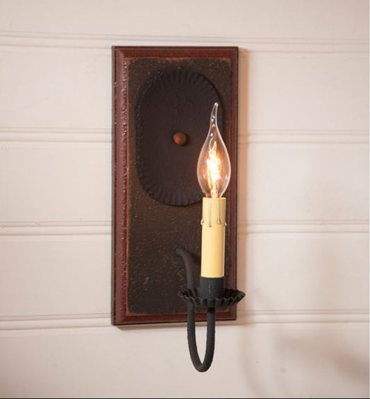 Wall-mounted light fixture with a vintage design on a neutral wall.