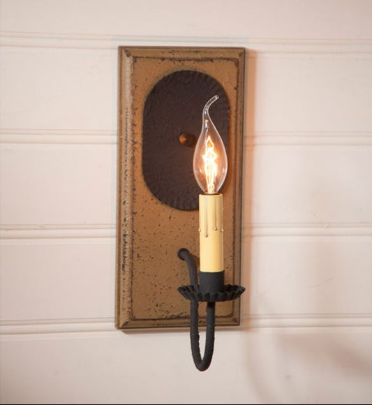 Decorative wall sconce with a lit candle-style bulb on a neutral background