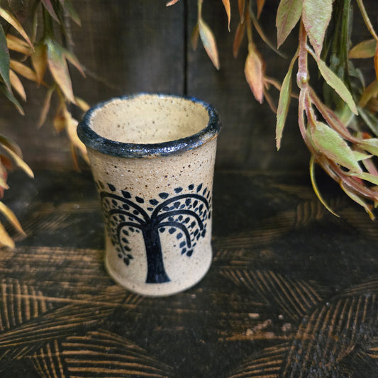 Ceramic cup with tree design on a wooden surface