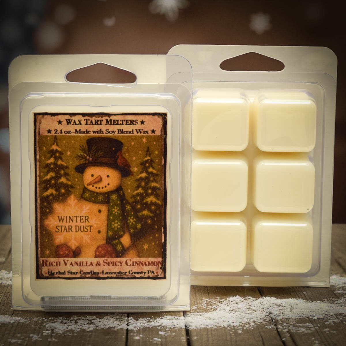 Wax tart melt package with snowman design and vanilla cinnamon scent on a wooden surface.
