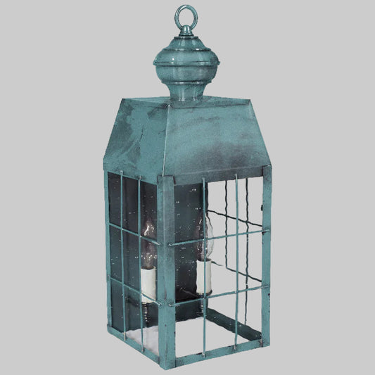 Teal metal lantern with glass panels on a white background
