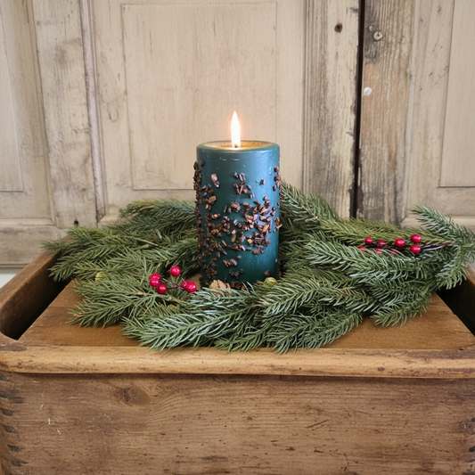 Blue candle with decorative elements on a wooden surface with a rustic background