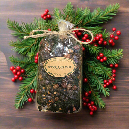 Pouch labeled 'Woodland Path' on a bed of green leaves