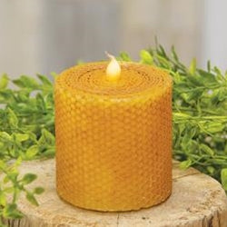 Wrapped honeycomb LED pillar 3" on wood stump with greenery in background