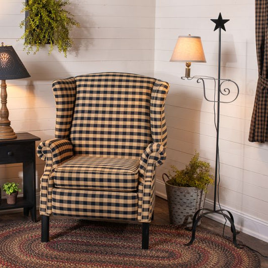 Checkered armchair in a room with a lamp, plant, and decorative rug.