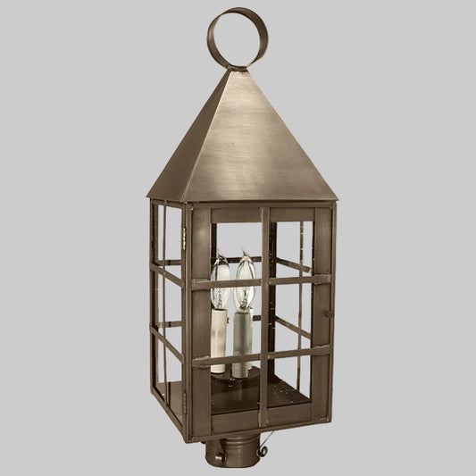 Bronze outdoor lantern with glass panels on a gray background