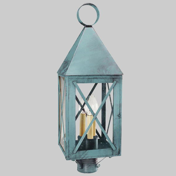 Decorative outdoor lantern with a metallic finish on a gray background