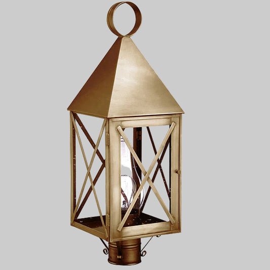 Decorative outdoor lantern with brass finish on a gray background