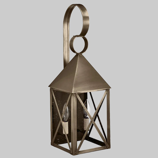 Bronze outdoor wall lantern with geometric design on a white background